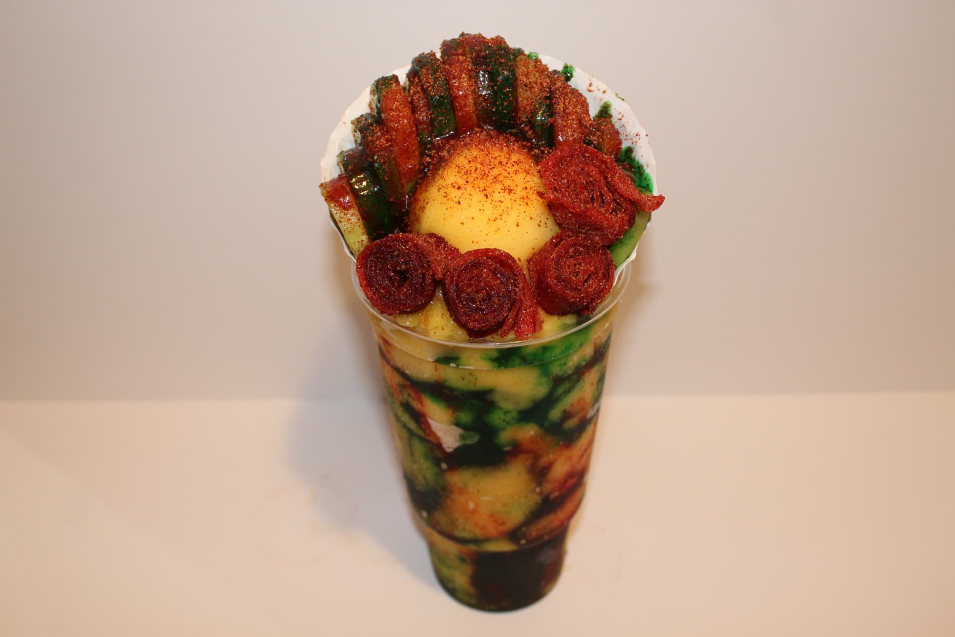 Loaded gorilla cup with mango scoop, cucumbers and chamoy rolls