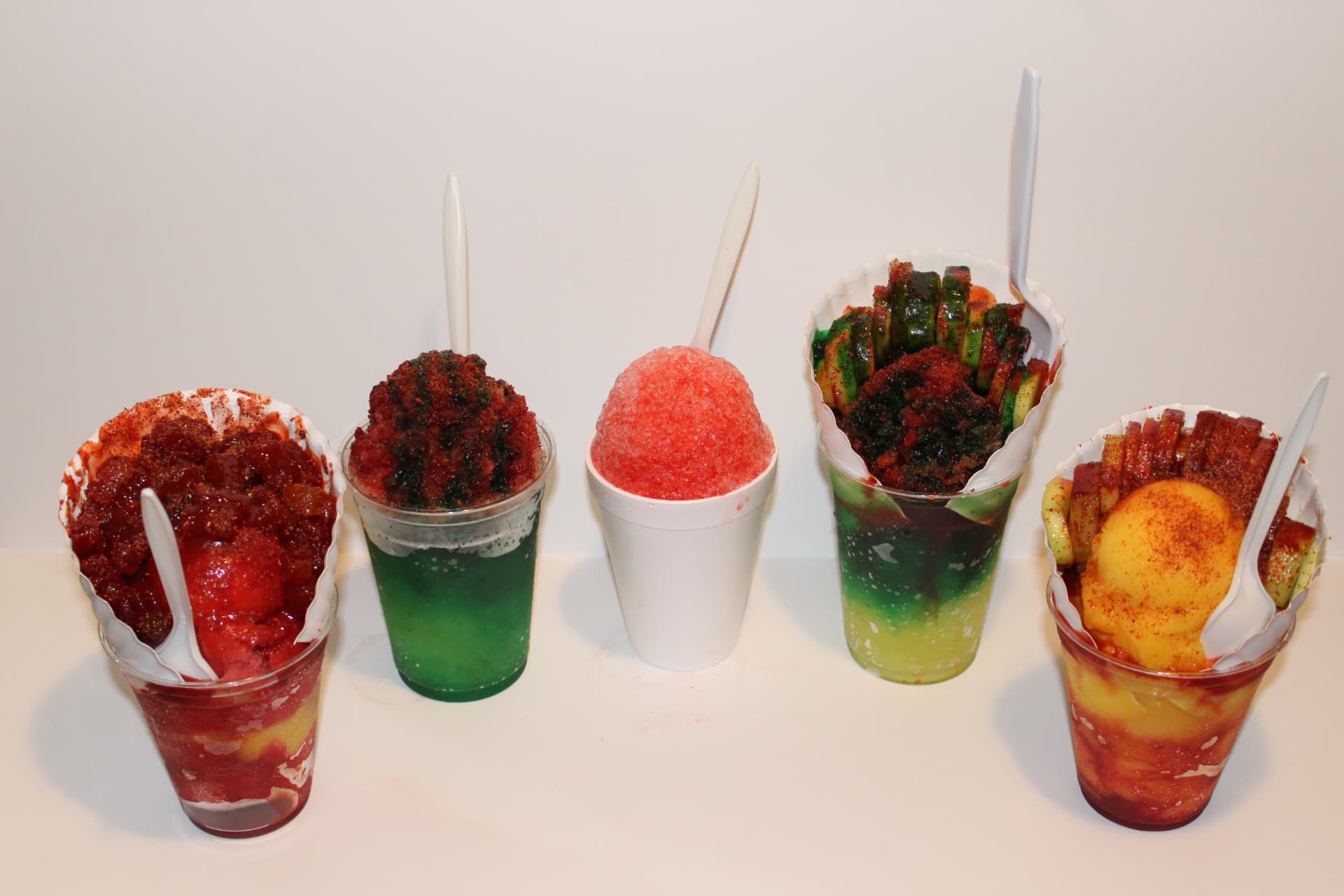 Lineup of shaved ice cups, chamoyadas and cucumber cups