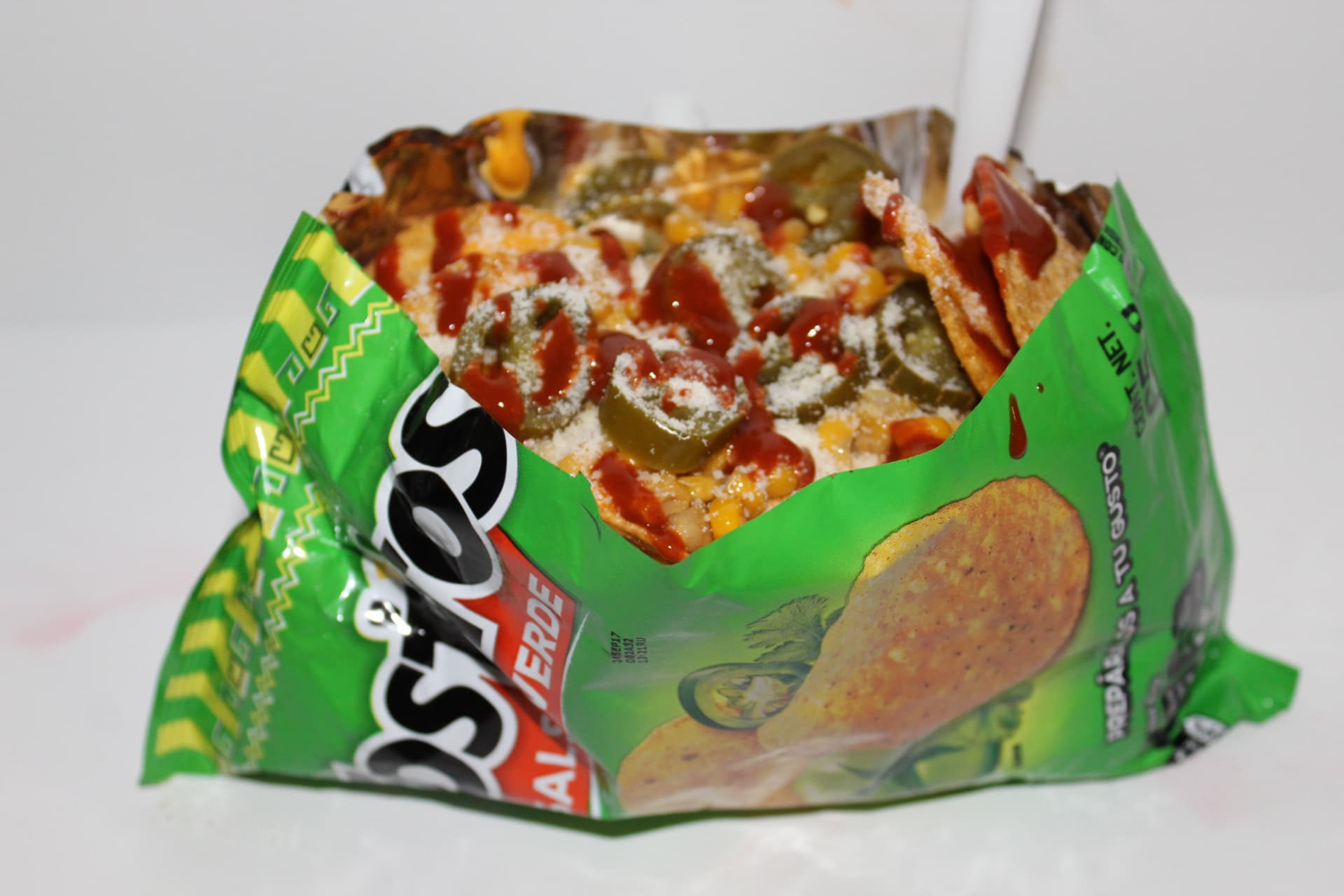 Tostilocos in the bag with cheese, corn, jalapeños and Valentina