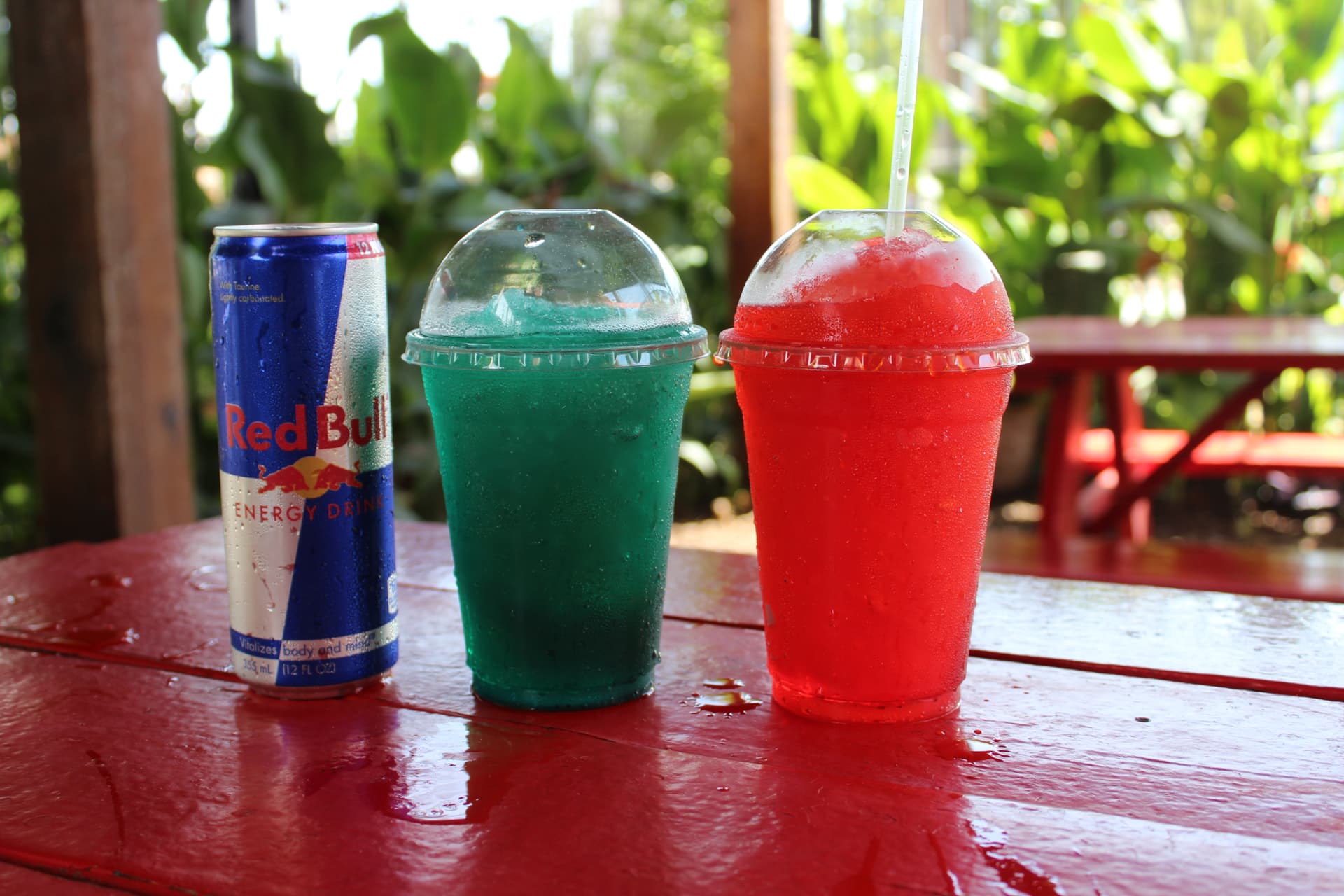 Frozen blue and red drinks next to a Red Bull can